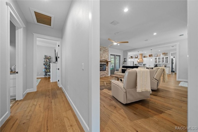 corridor with recessed lighting, light wood-type flooring, visible vents, and baseboards