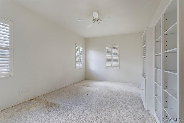 carpeted empty room featuring ceiling fan