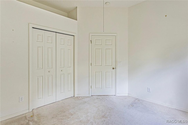 unfurnished bedroom with carpet flooring, a high ceiling, and a closet