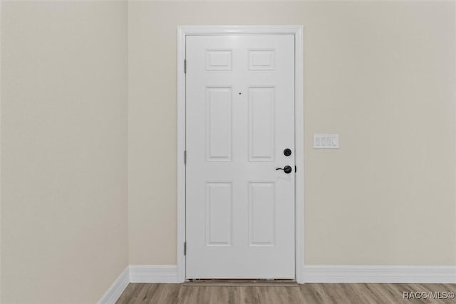 doorway to outside with light wood-type flooring and baseboards