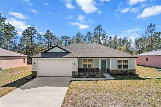 view of front of property with stone siding, concrete driveway, and a front yard