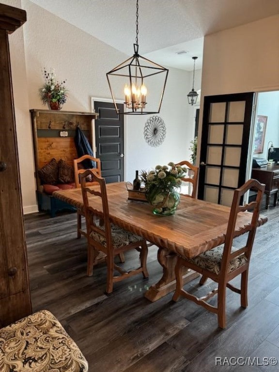 dining area with dark hardwood / wood-style flooring, a chandelier, and vaulted ceiling