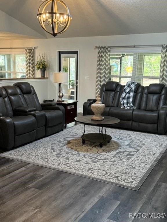 living room with dark hardwood / wood-style flooring, vaulted ceiling, a textured ceiling, and an inviting chandelier