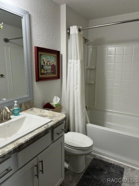 full bathroom featuring shower / tub combo, vanity, a textured ceiling, and toilet