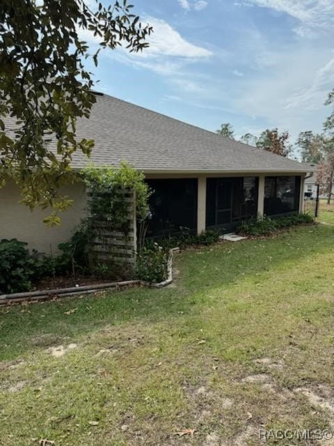 view of side of property with a sunroom and a yard