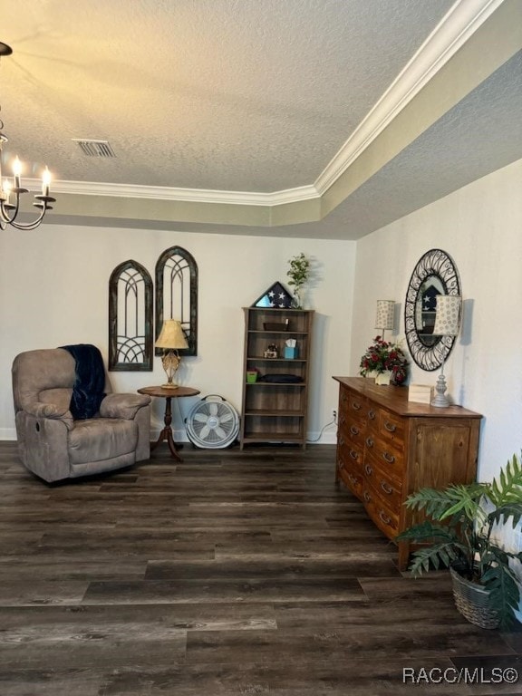 sitting room with dark hardwood / wood-style flooring, a textured ceiling, a tray ceiling, and an inviting chandelier