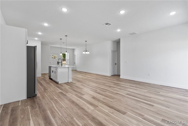 1413 W America Pl, Citrus Springs, FL 34434 - unfurnished living room featuring a sink, recessed lighting, visible vents, and light wood-style floors