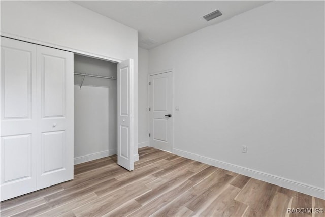 1413 W America Pl, Citrus Springs, FL 34434 - unfurnished bedroom with baseboards, visible vents, light wood-type flooring, and a closet