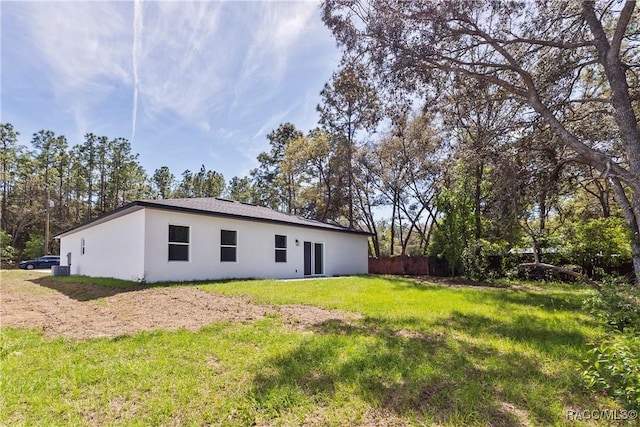 1413 W America Pl, Citrus Springs, FL 34434 - back of house featuring fence, stucco siding, and a yard