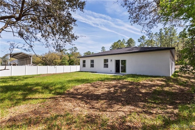 1413 W America Pl, Citrus Springs, FL 34434 - back of property with a yard, a detached carport, stucco siding, and fence
