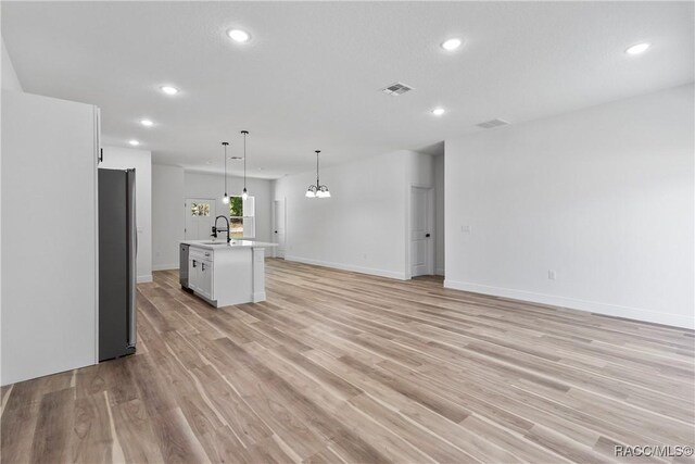 1413 W America Pl, Citrus Springs, FL 34434 - unfurnished living room with recessed lighting, light wood finished floors, a sink, baseboards, and visible vents