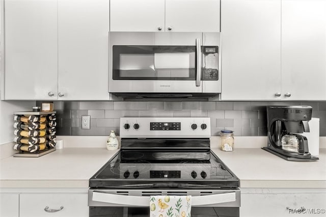 kitchen featuring white cabinets, backsplash, and stainless steel appliances