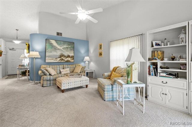 living room with ceiling fan, light colored carpet, and vaulted ceiling