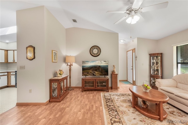 living area with visible vents, baseboards, ceiling fan, vaulted ceiling, and light wood-style floors