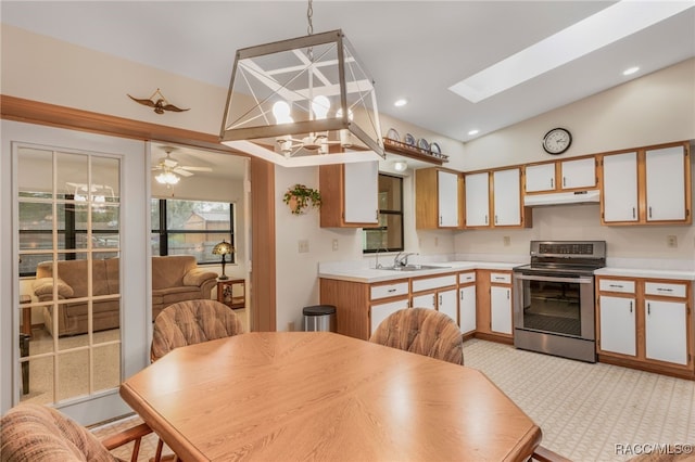 kitchen with electric range, a sink, light countertops, under cabinet range hood, and lofted ceiling with skylight