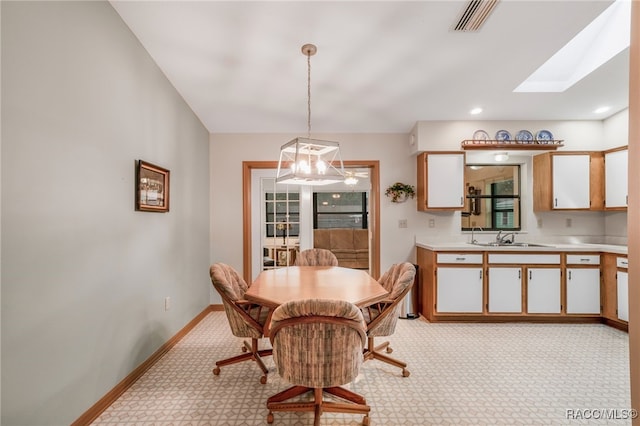 dining area featuring baseboards, visible vents, a skylight, recessed lighting, and light carpet