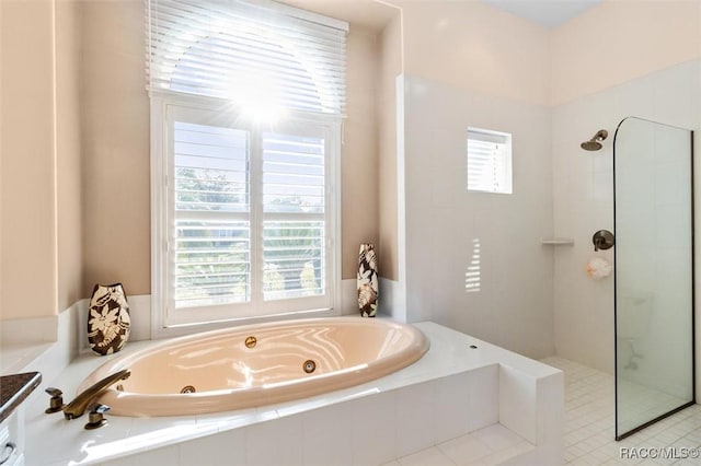 bathroom featuring a wealth of natural light and separate shower and tub