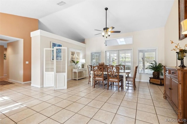 tiled dining space with ceiling fan and lofted ceiling