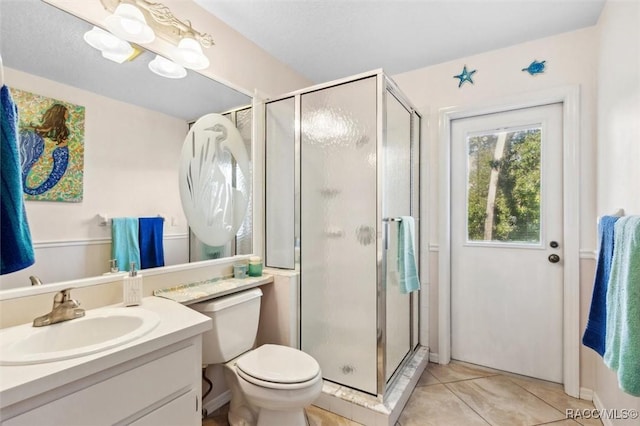 bathroom featuring vanity, tile patterned flooring, a shower with shower door, and toilet