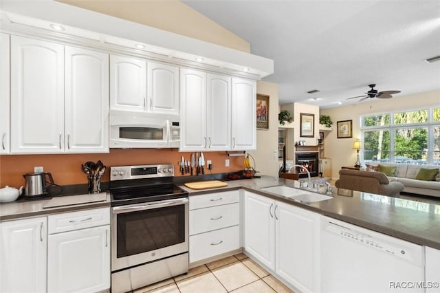 kitchen featuring sink, white appliances, white cabinetry, light tile patterned flooring, and kitchen peninsula