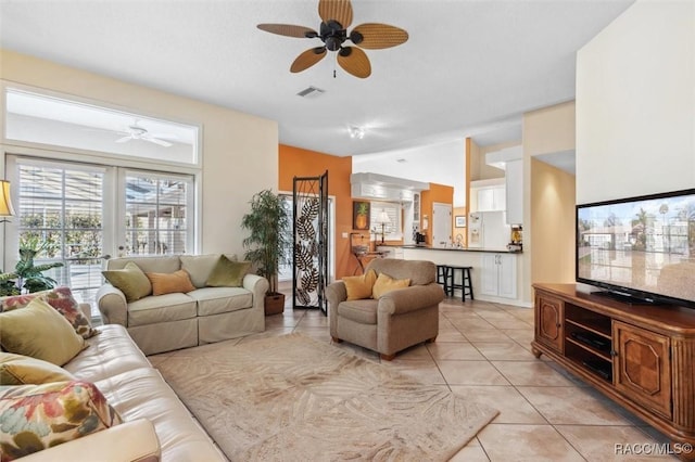 living room featuring light tile patterned floors, vaulted ceiling, french doors, and ceiling fan