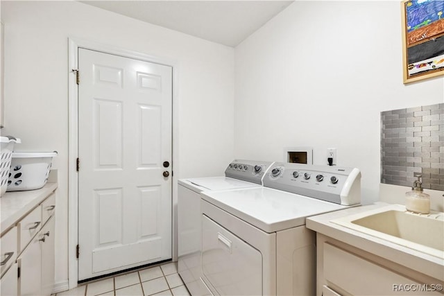 laundry room with cabinets, light tile patterned floors, and washing machine and clothes dryer