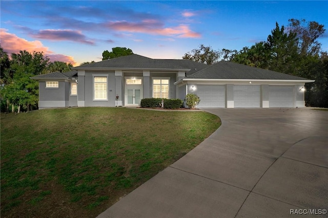 view of front of property featuring a lawn and a garage