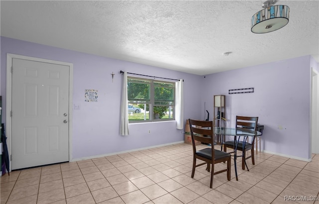 tiled dining space featuring a textured ceiling