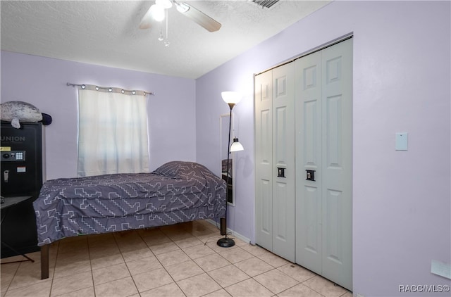 bedroom featuring light tile patterned floors, a textured ceiling, and ceiling fan