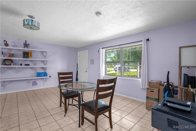 tiled dining room featuring a textured ceiling