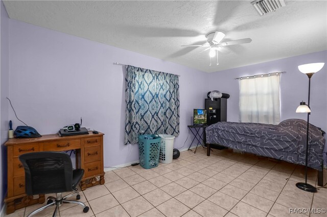 tiled bedroom with a textured ceiling and ceiling fan