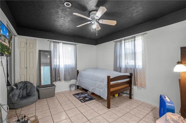 tiled bedroom featuring a textured ceiling and ceiling fan