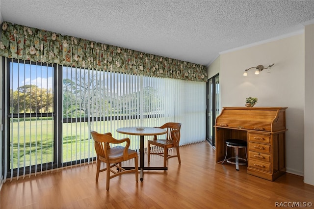 dining room with wood-type flooring and a textured ceiling