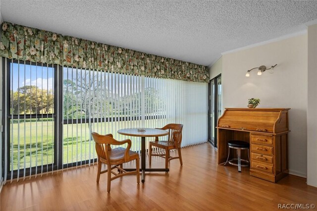 dining area featuring ornamental molding, hardwood / wood-style floors, and a textured ceiling