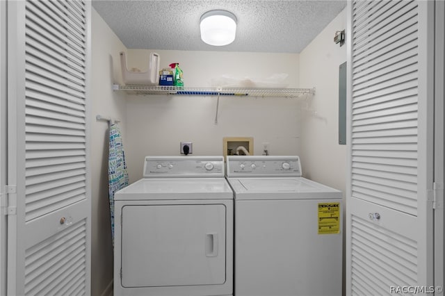 clothes washing area featuring washing machine and clothes dryer and a textured ceiling