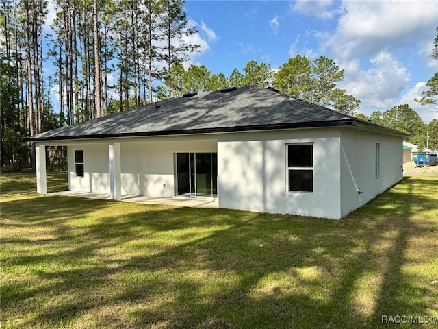 7549 N Santos Dr, Citrus Springs, FL 34434 - rear view of property featuring stucco siding, a lawn, roof with shingles, and a patio