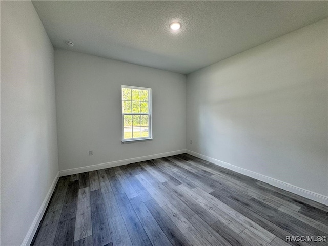7549 N Santos Dr, Citrus Springs, FL 34434 - empty room with dark wood-style flooring, a textured ceiling, and baseboards