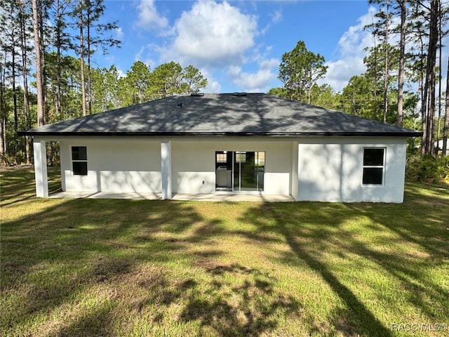 7549 N Santos Dr, Citrus Springs, FL 34434 - rear view of house with stucco siding, a lawn, and a patio