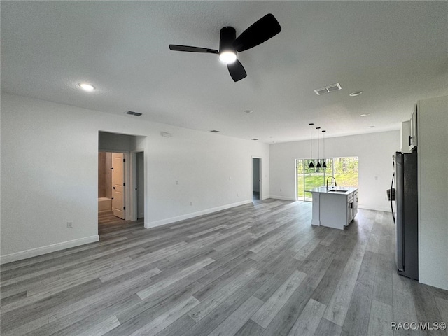 7549 N Santos Dr, Citrus Springs, FL 34434 - unfurnished living room with a sink, ceiling fan, light wood-type flooring, recessed lighting, and baseboards