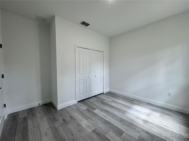 7549 N Santos Dr, Citrus Springs, FL 34434 - unfurnished bedroom featuring wood finished floors, baseboards, and a closet