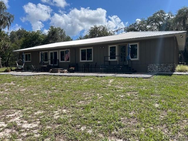 5870 N Briarclifrf Ter, Hernando, FL 34442 - view of front facade with a patio, a front lawn, and a metal roof