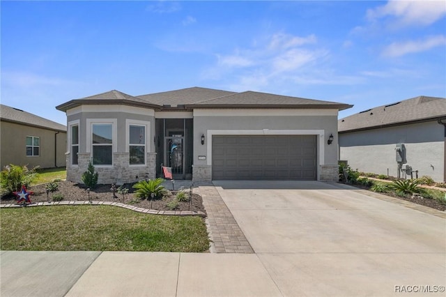 prairie-style home with stucco siding, stone siding, driveway, and an attached garage