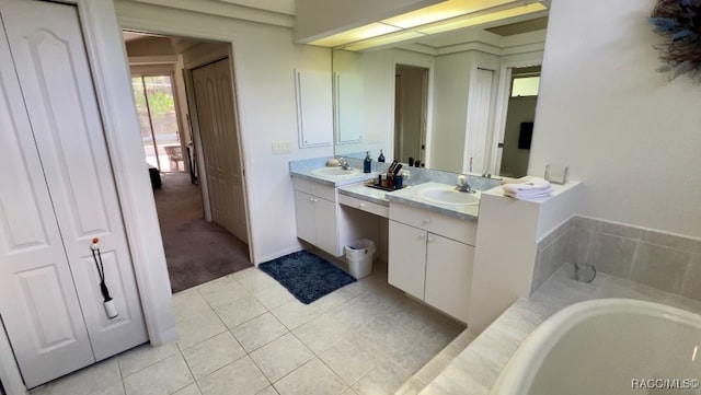 bathroom featuring tile patterned flooring, vanity, and a washtub