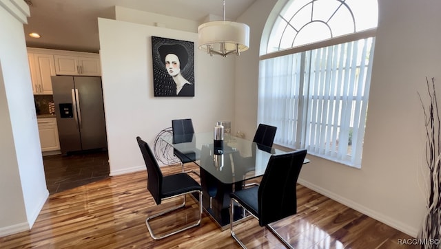 dining area featuring an inviting chandelier and hardwood / wood-style flooring