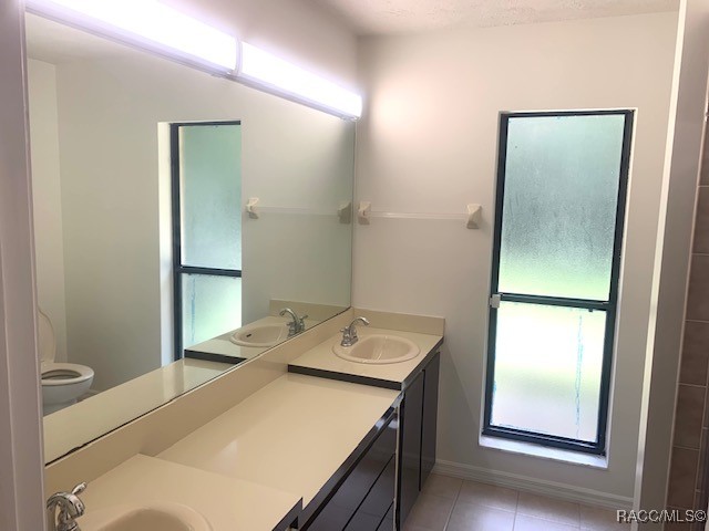 bathroom featuring tile patterned flooring, vanity, and toilet