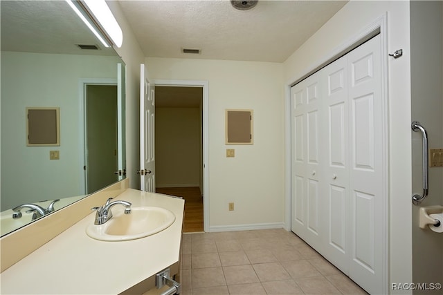 bathroom featuring vanity, a textured ceiling, and tile patterned floors