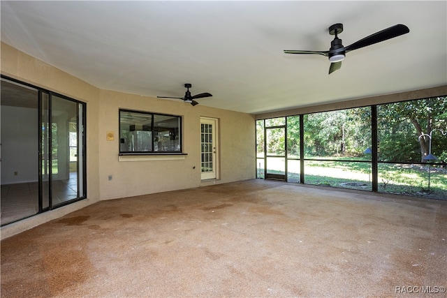 unfurnished sunroom with ceiling fan