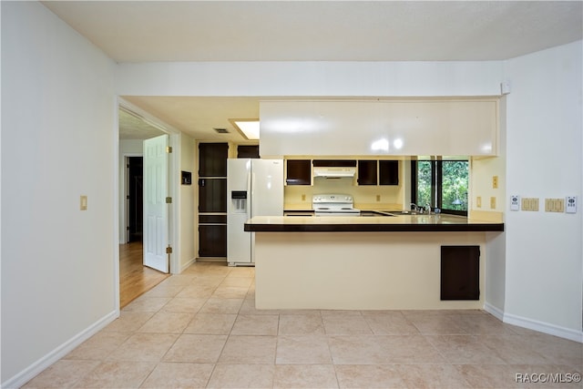 kitchen with kitchen peninsula, sink, light tile patterned flooring, and white appliances