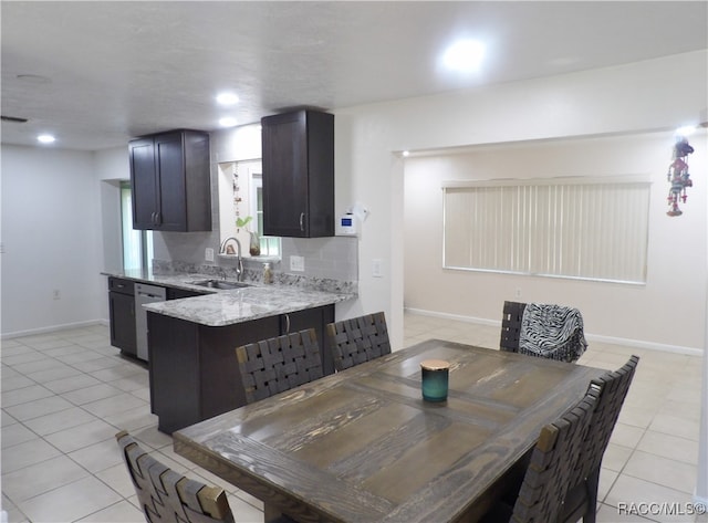 dining area featuring sink and light tile patterned floors