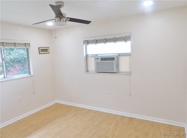 empty room with ceiling fan, cooling unit, and wood-type flooring